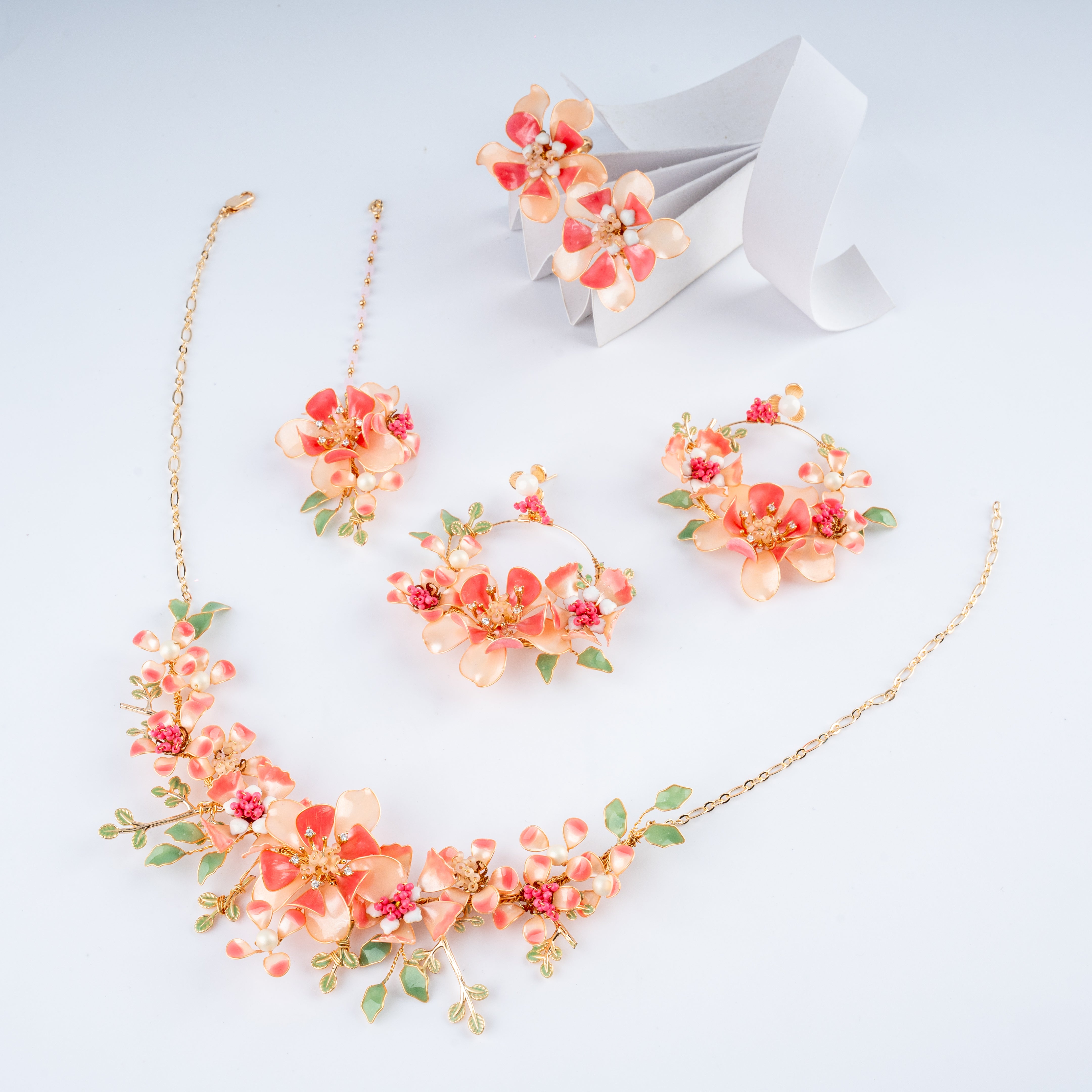 Coral and peach floral resin art jewelry set with collar necklace, hoop earrings, maang tikka, and rings from US Catalog.   