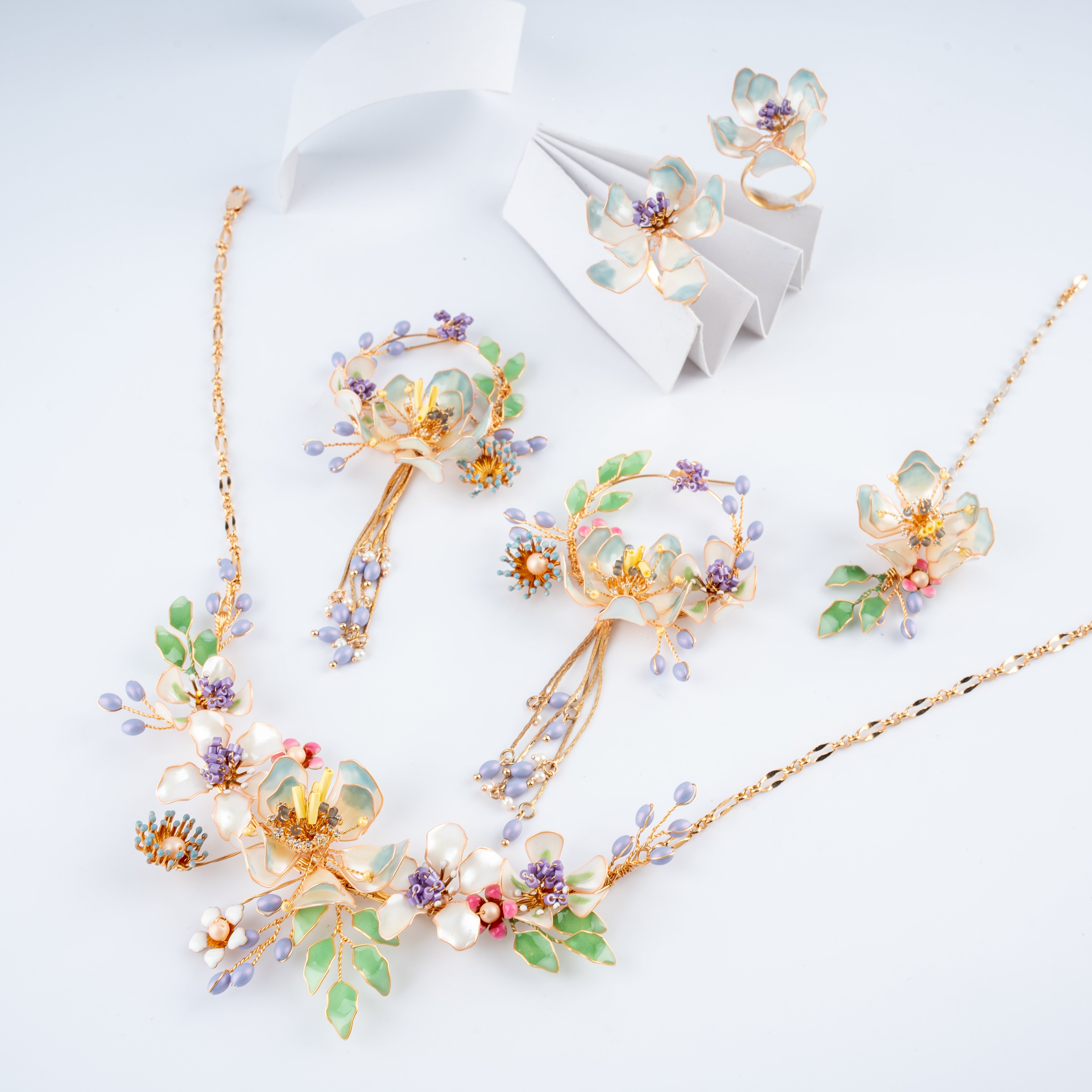 Lavender and pastel green floral resin art jewelry set with necklace, tassel earrings, maang tikka, and rings from US Catalog.   