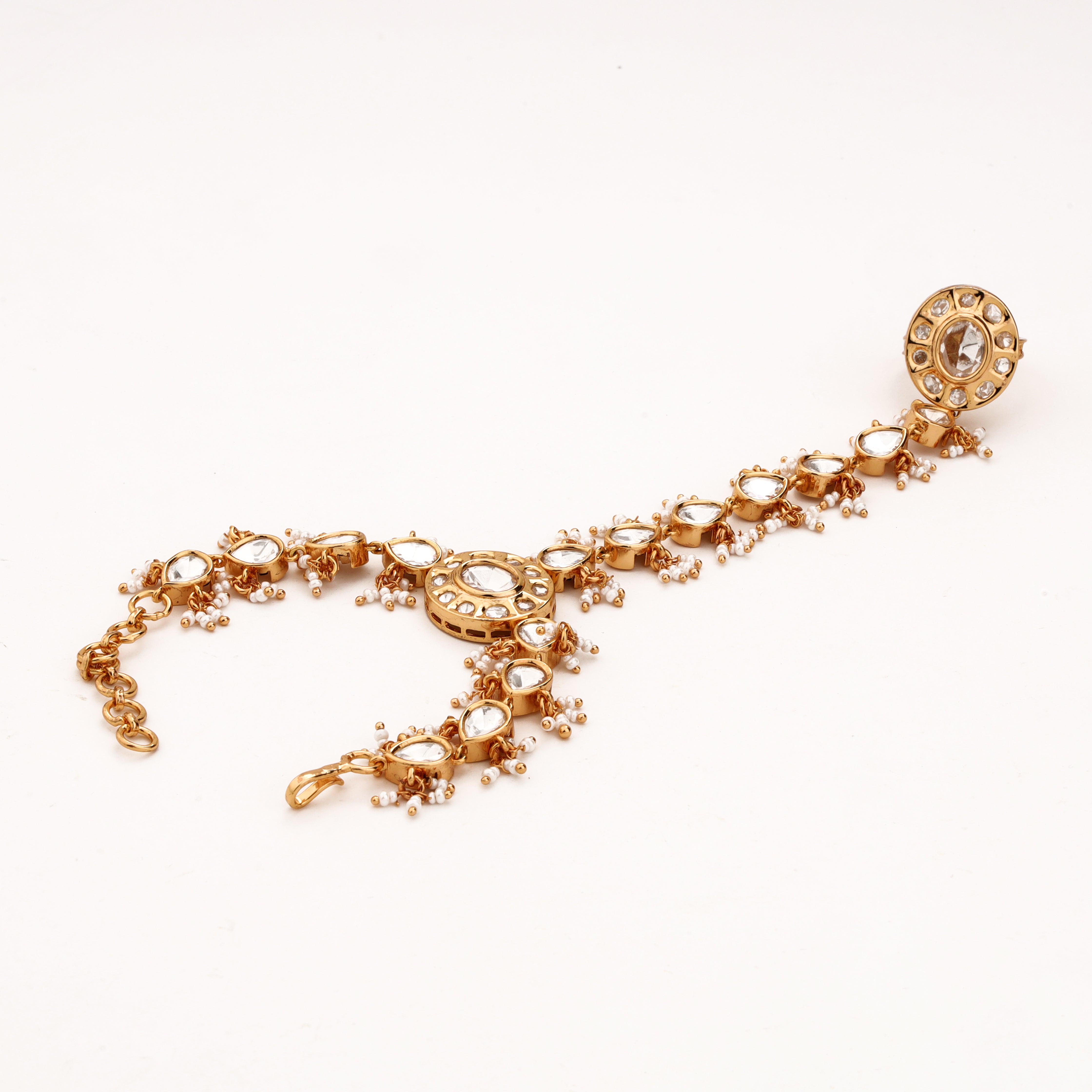 Gold-tone teardrop kundan pearl pocha with clear stones, circular motifs and adjustable wrist chain