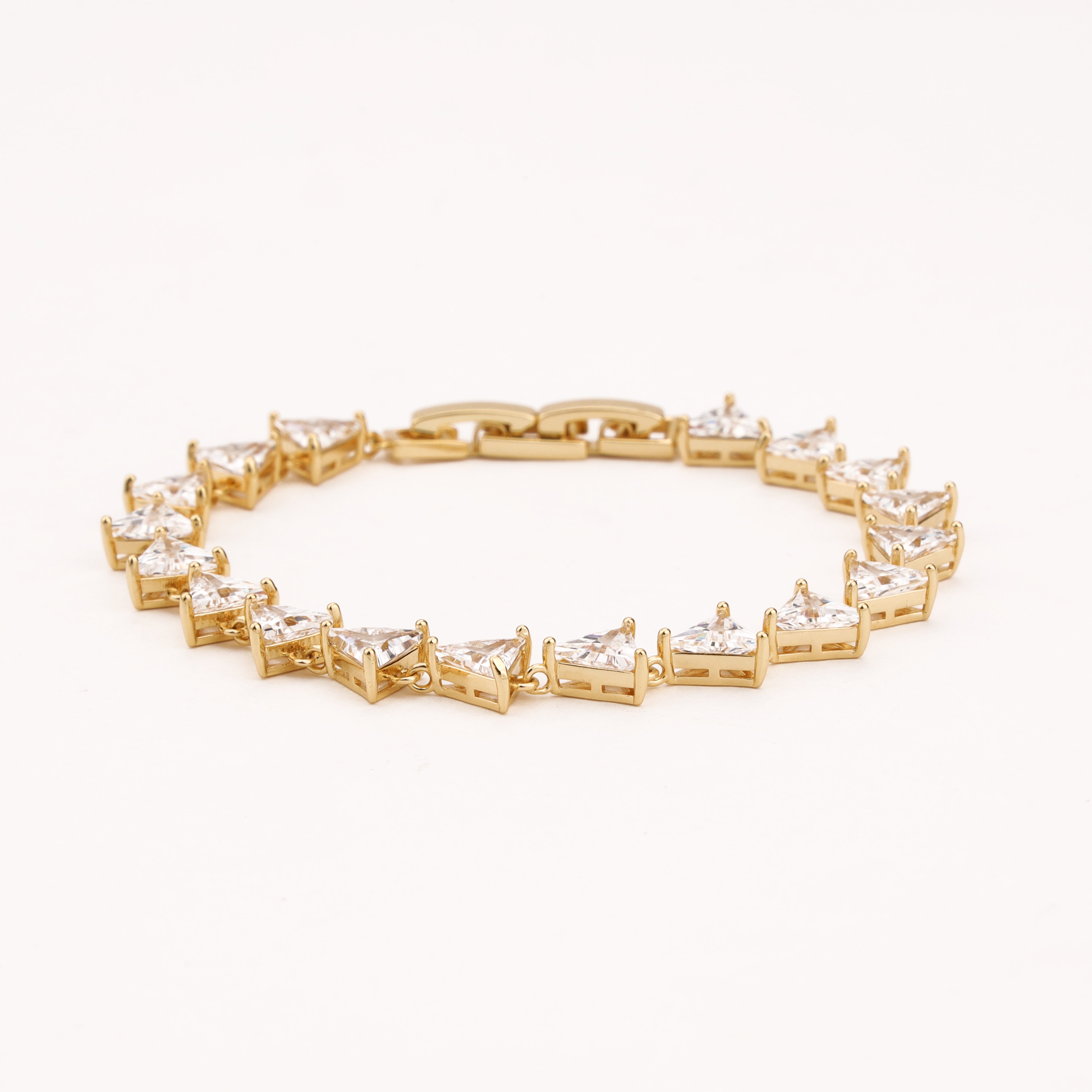Trielle gold-tone link bracelet with a continuous row of faceted clear triangular crystal stones