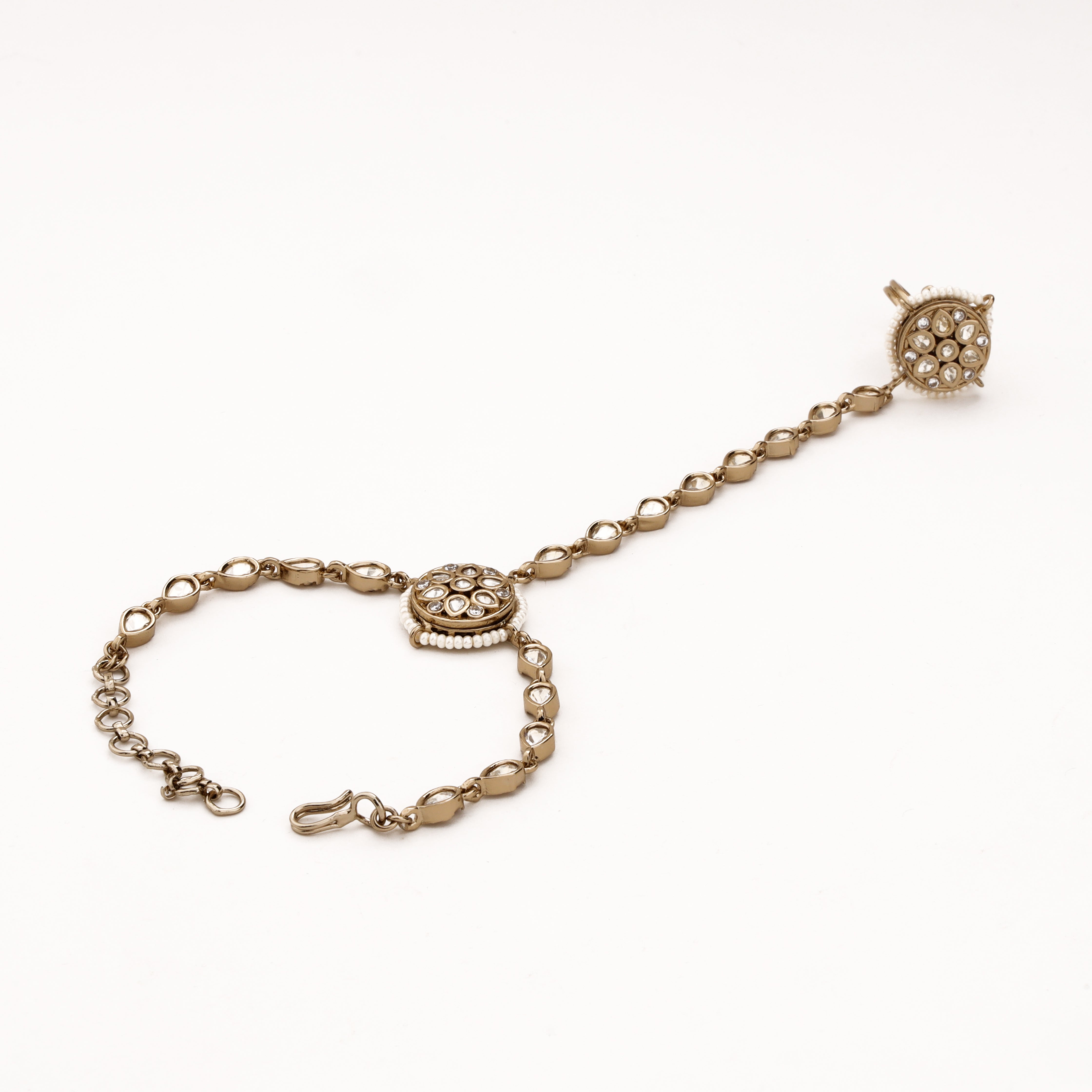 Antique silver pearl halo kundan pocha with clear teardrop stones, circular motifs and adjustable wrist chain