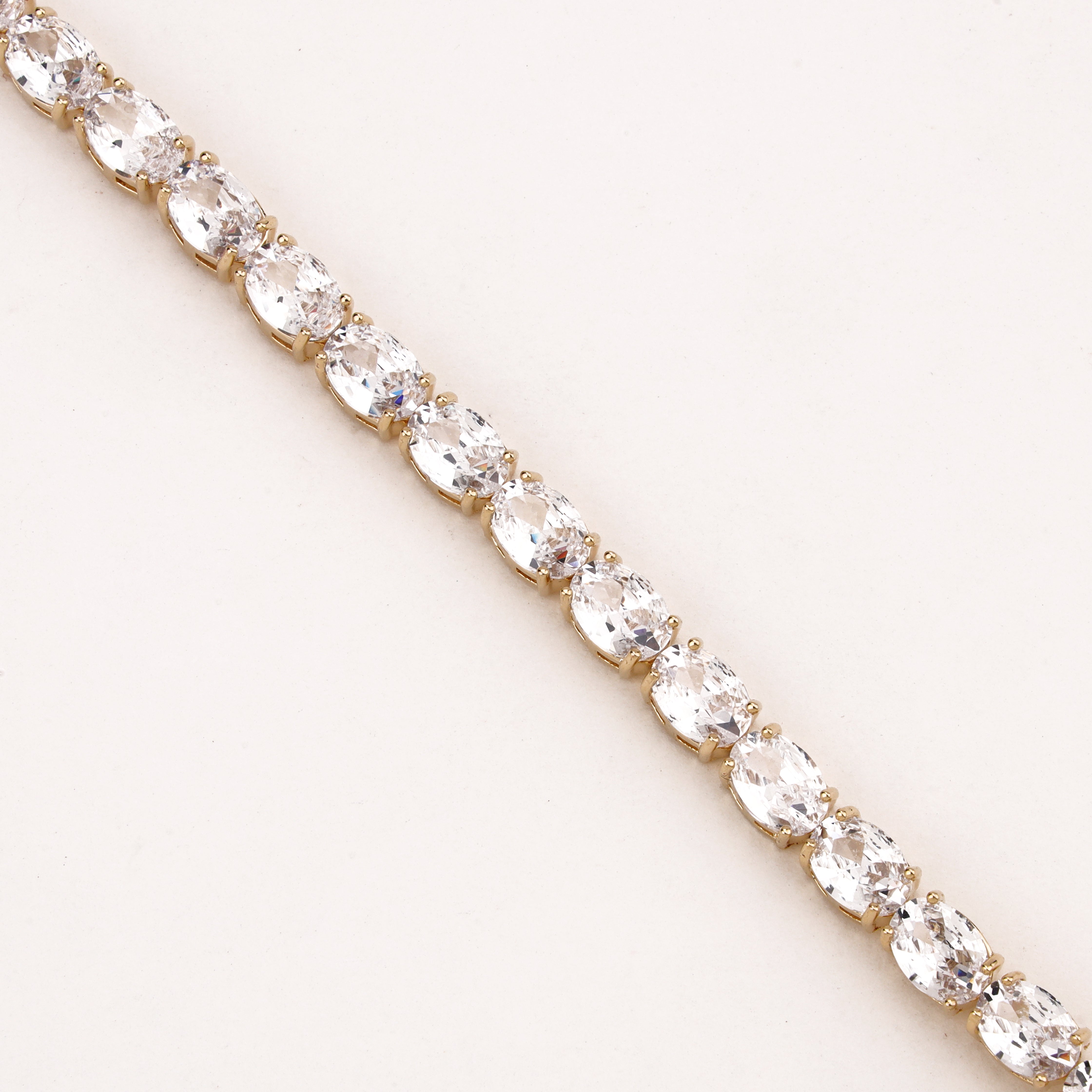 Marielle gold-tone tennis bracelet with a continuous row of oval-cut clear crystal stones