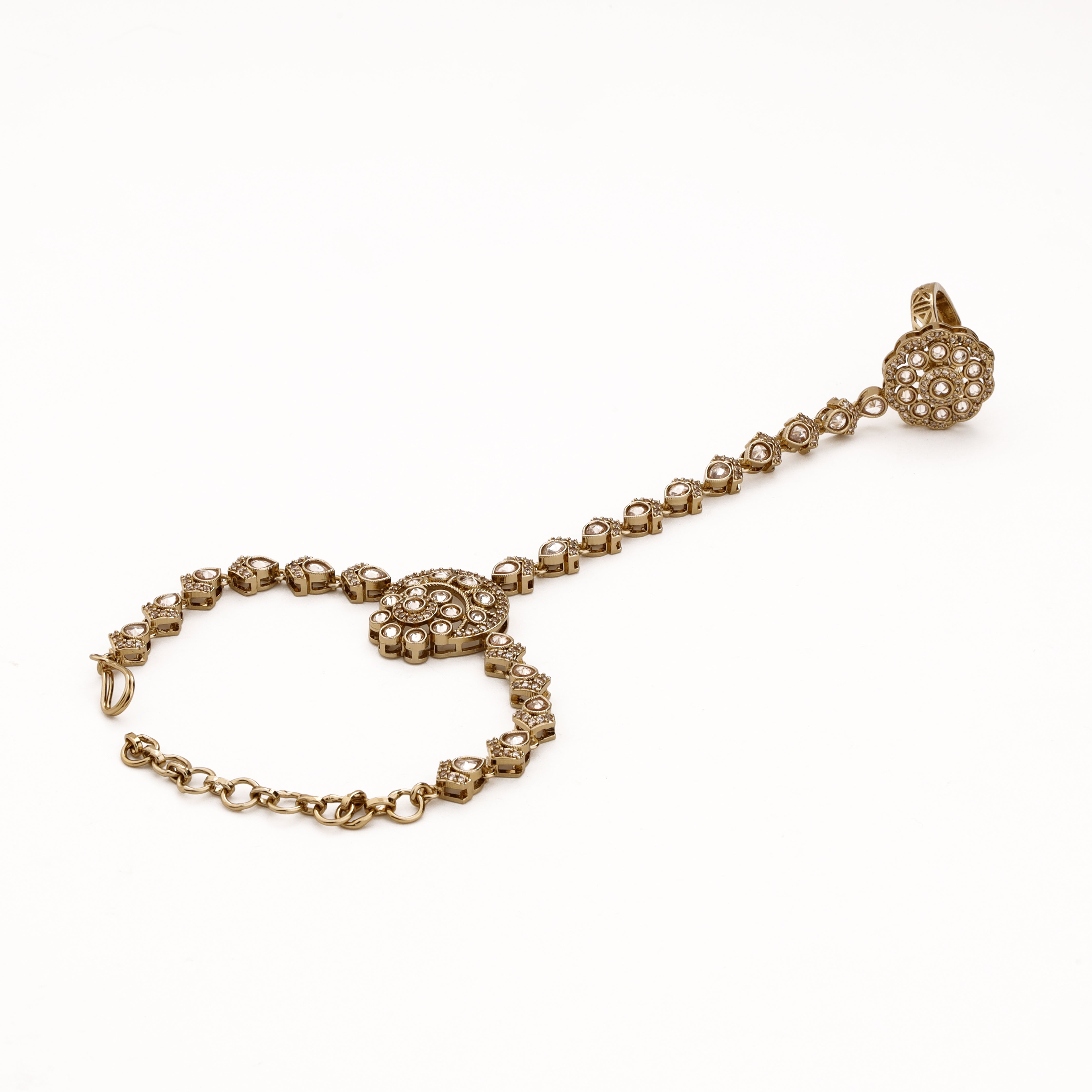 Antique gold circular kundan pocha with reflective stone links, statement finger ring and adjustable wrist chain