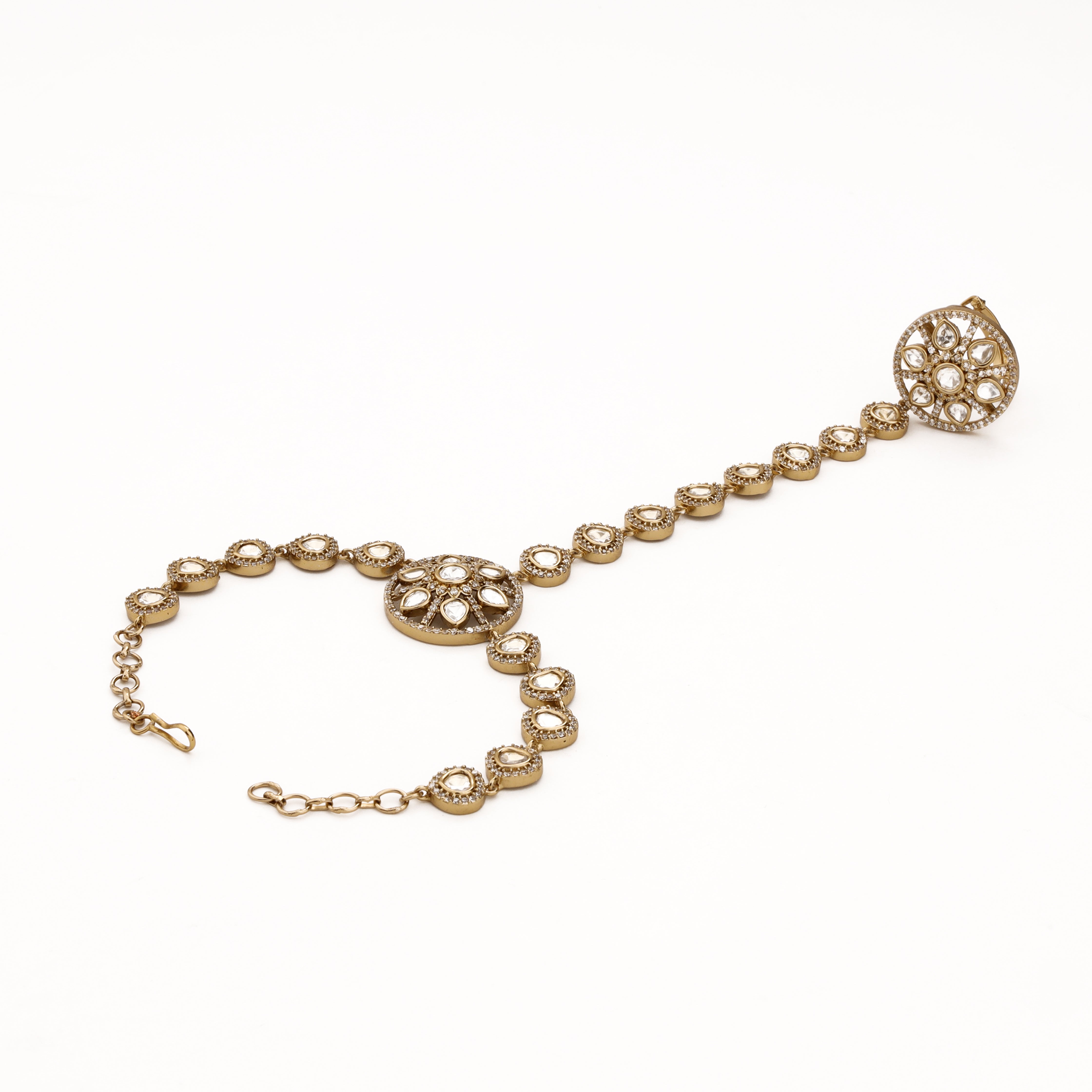Gold circular floral kundan pocha with teardrop stone links, crystal halo motifs and adjustable wrist chain