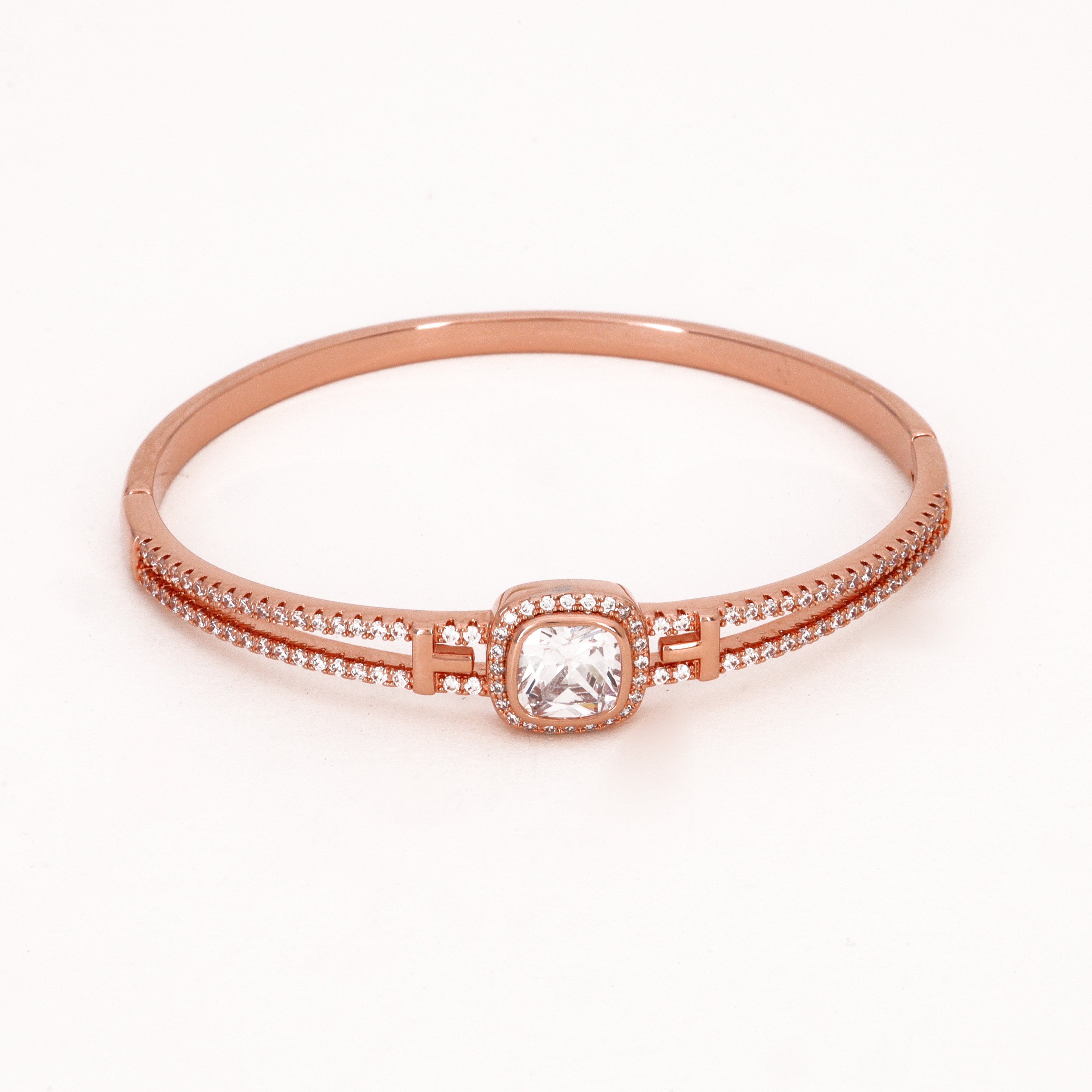 Rose Gold Tone Cushion Halo Double Band Bracelet featuring a cushion-cut center stone with geometric connectors and a split pavé band on a white background for US Catalog.