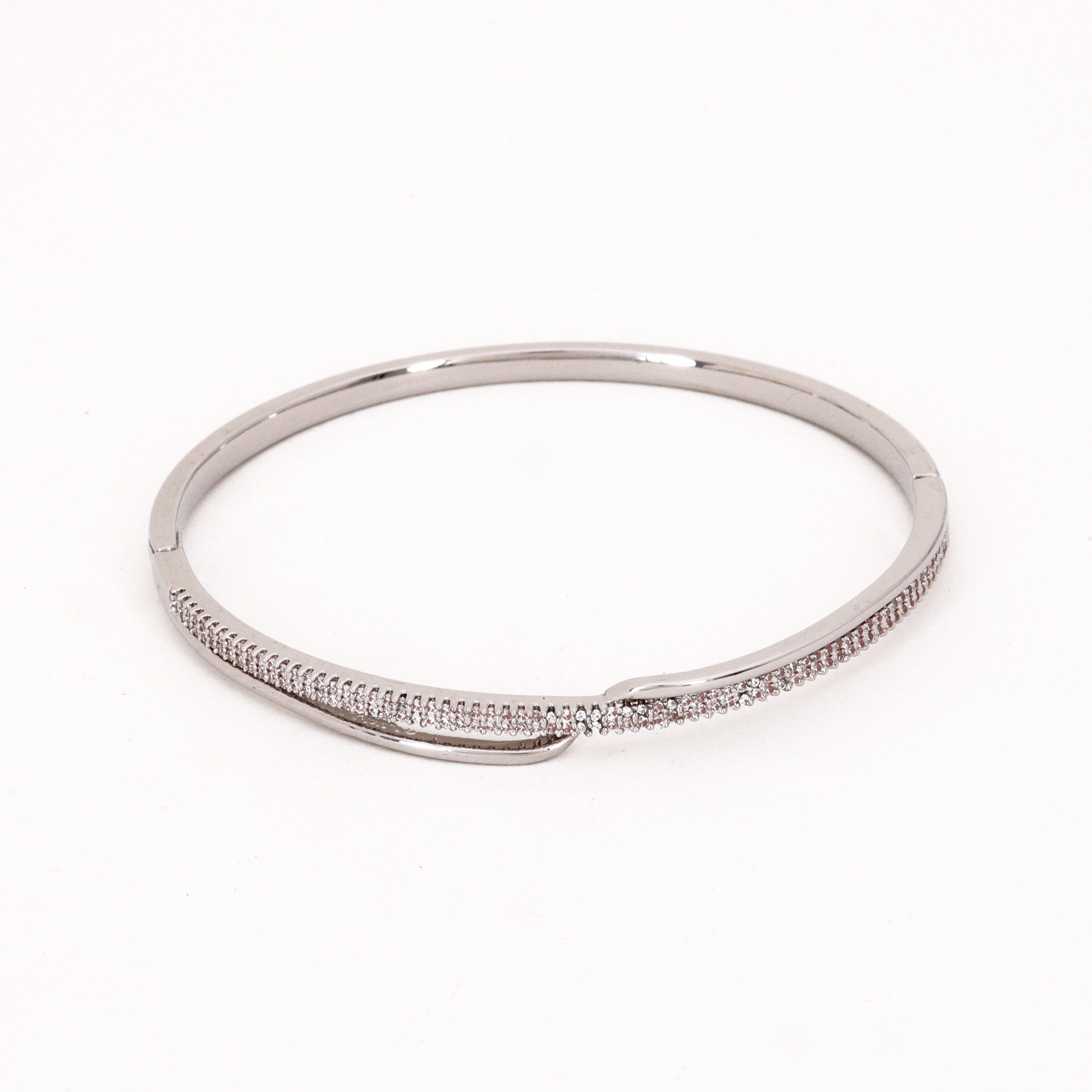Crystal Asymmetrical Overlap Bracelet featuring a sleek metallic band and a continuous line of pavé crystals on a studio background, referencing IMG_0066.jpg for US Catalog.
