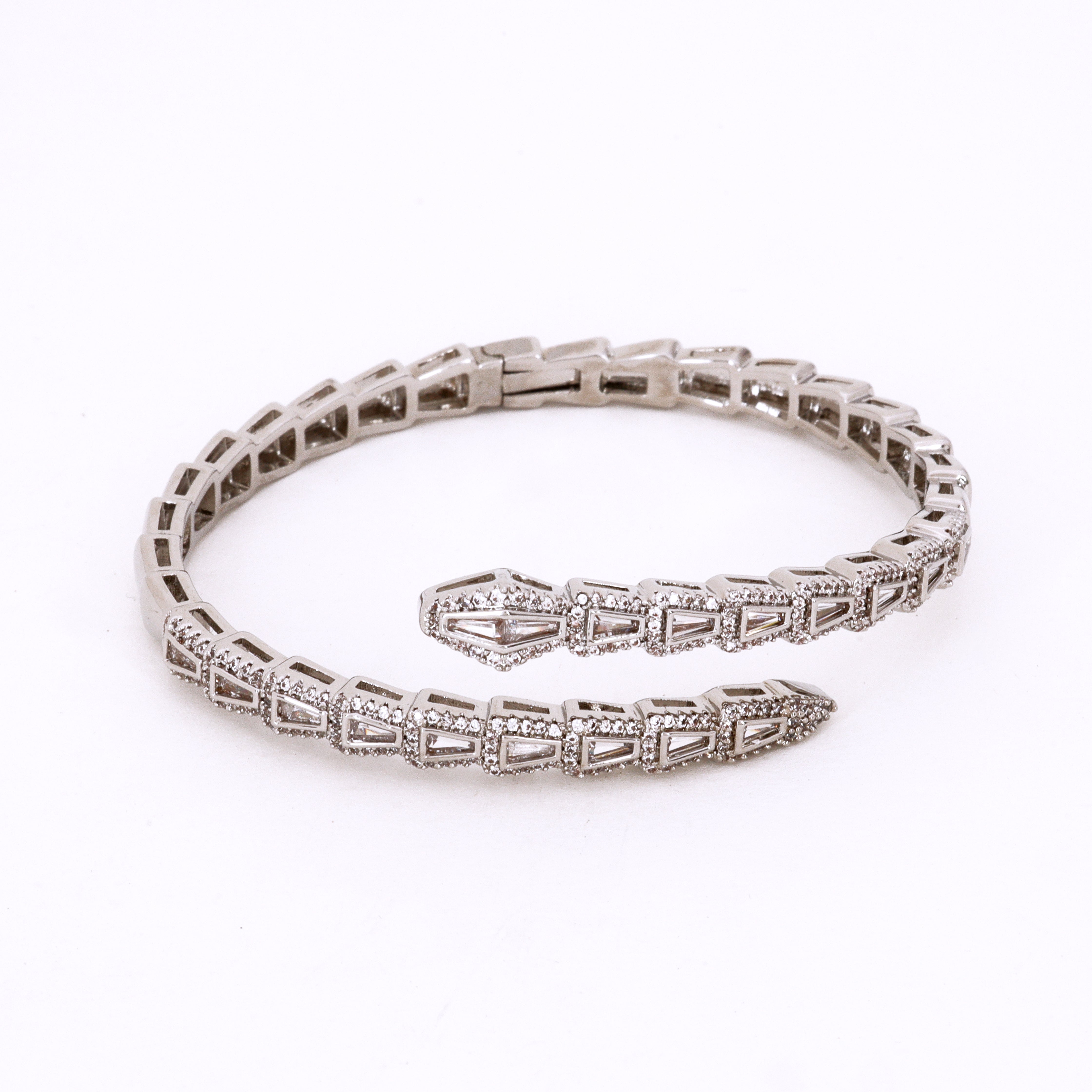 Silver Tone Crystal Serpent Coil Bracelet featuring an intricate snake-inspired wrap design with baguette crystal insets and pavé detailing on a studio background for US Catalog.