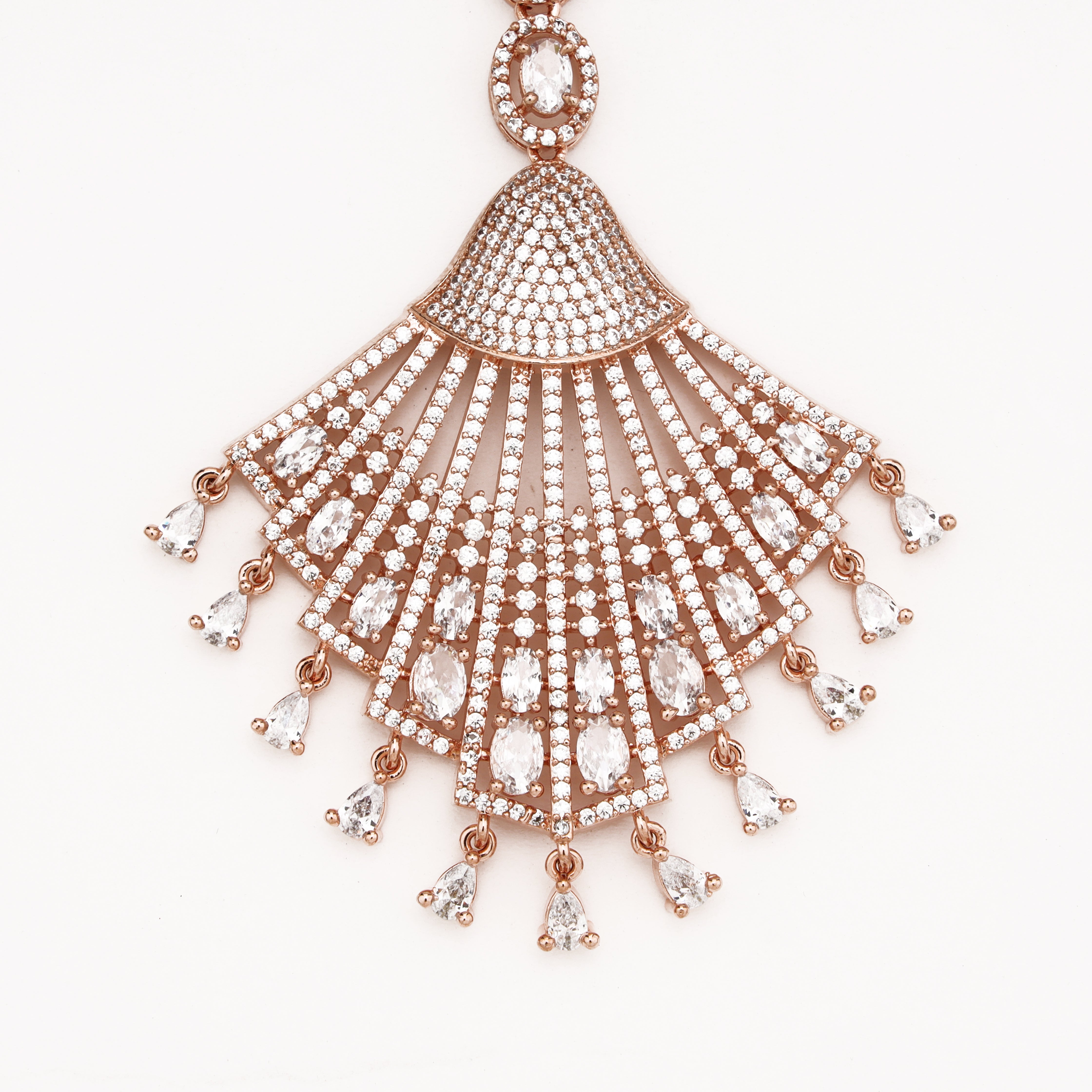Rose gold fan-shaped pendant necklace with clear pavé stones and teardrop dangling accents, shown on a plain white background.