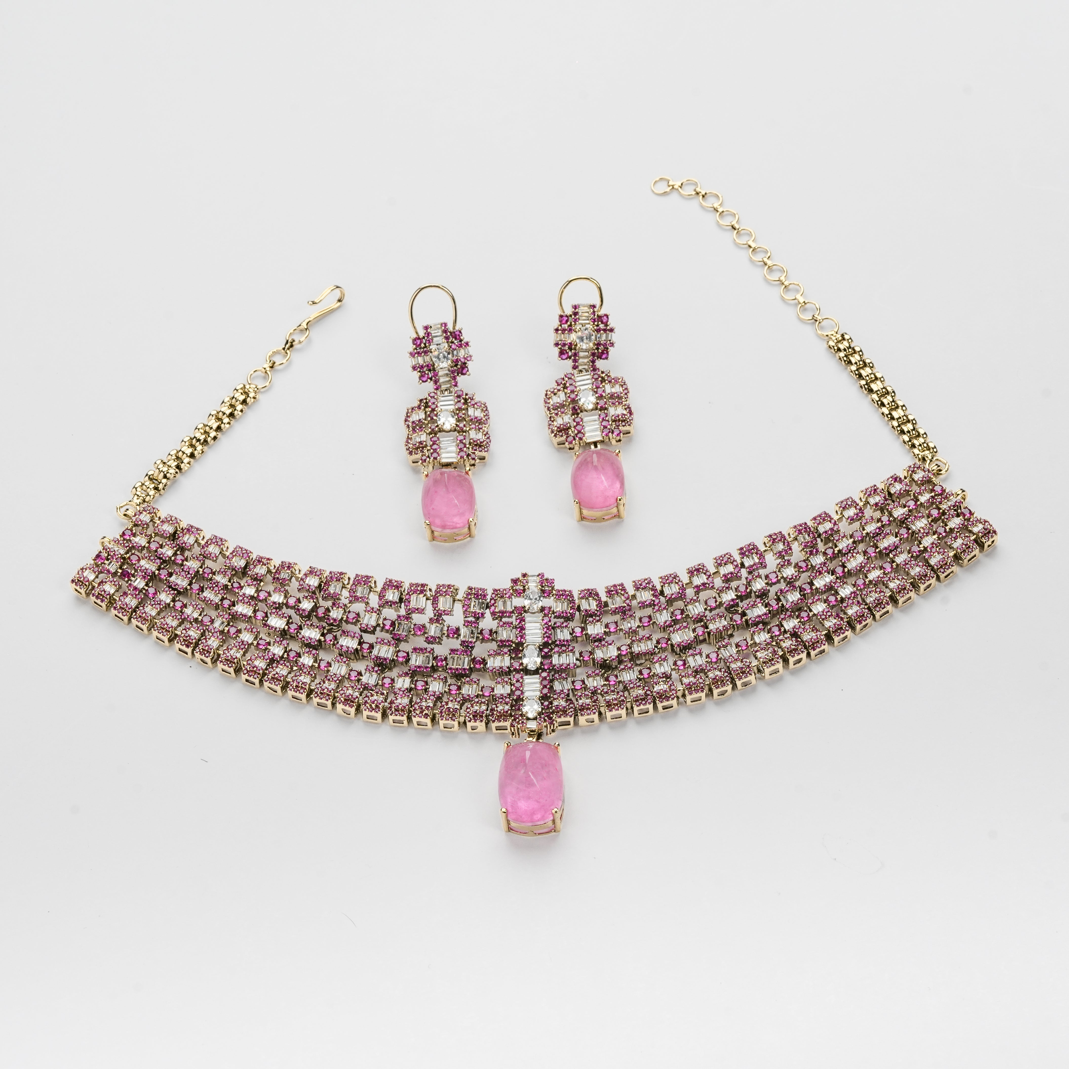 Gold-plated jewelry set featuring a wide choker necklace and matching drop earrings, embellished with rows of pink and clear rhinestones and a teardrop-shaped pink stone at the center.