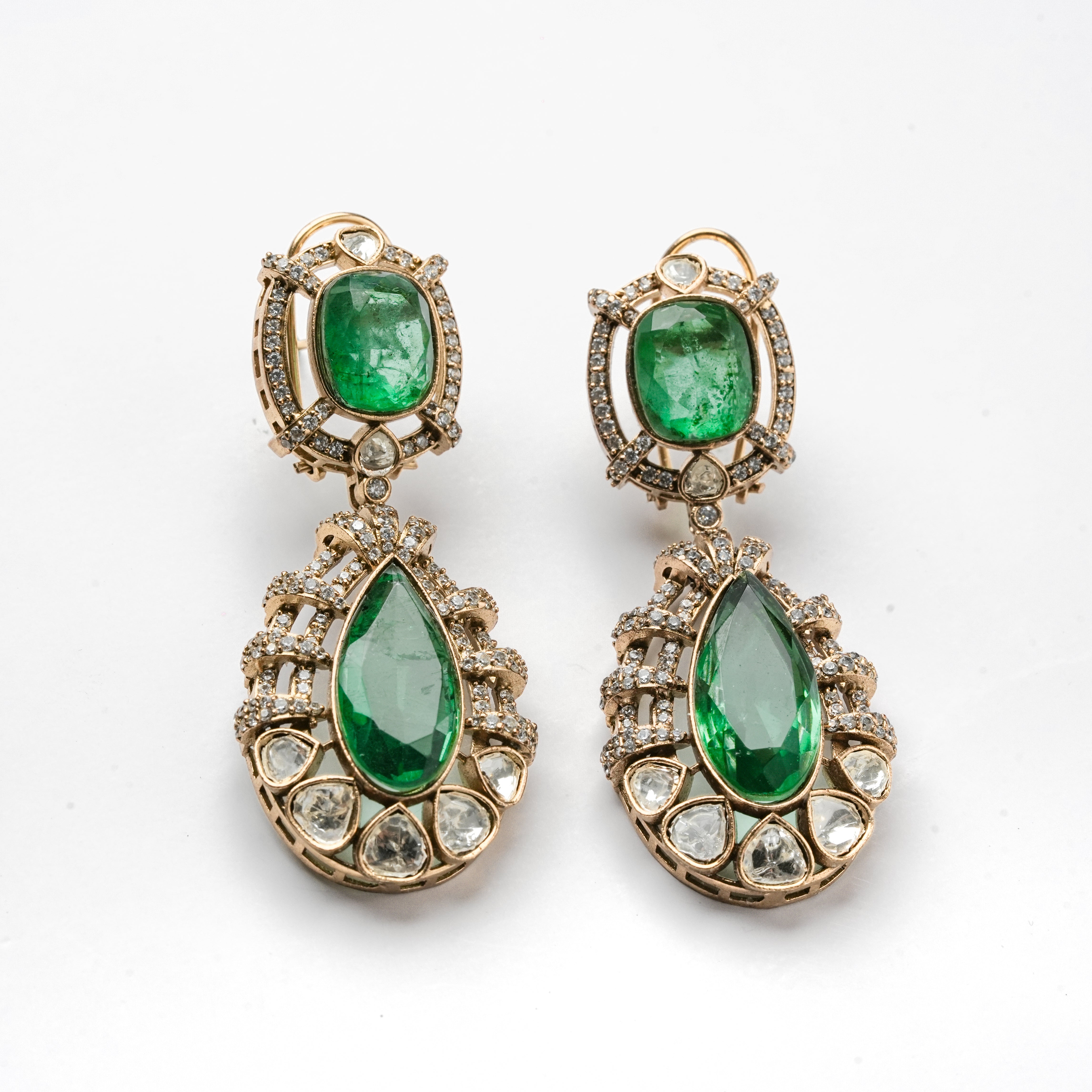 Antique gold finish green stone kundan polki necklace set with teardrop drops and matching drop earrings for bridal wear.