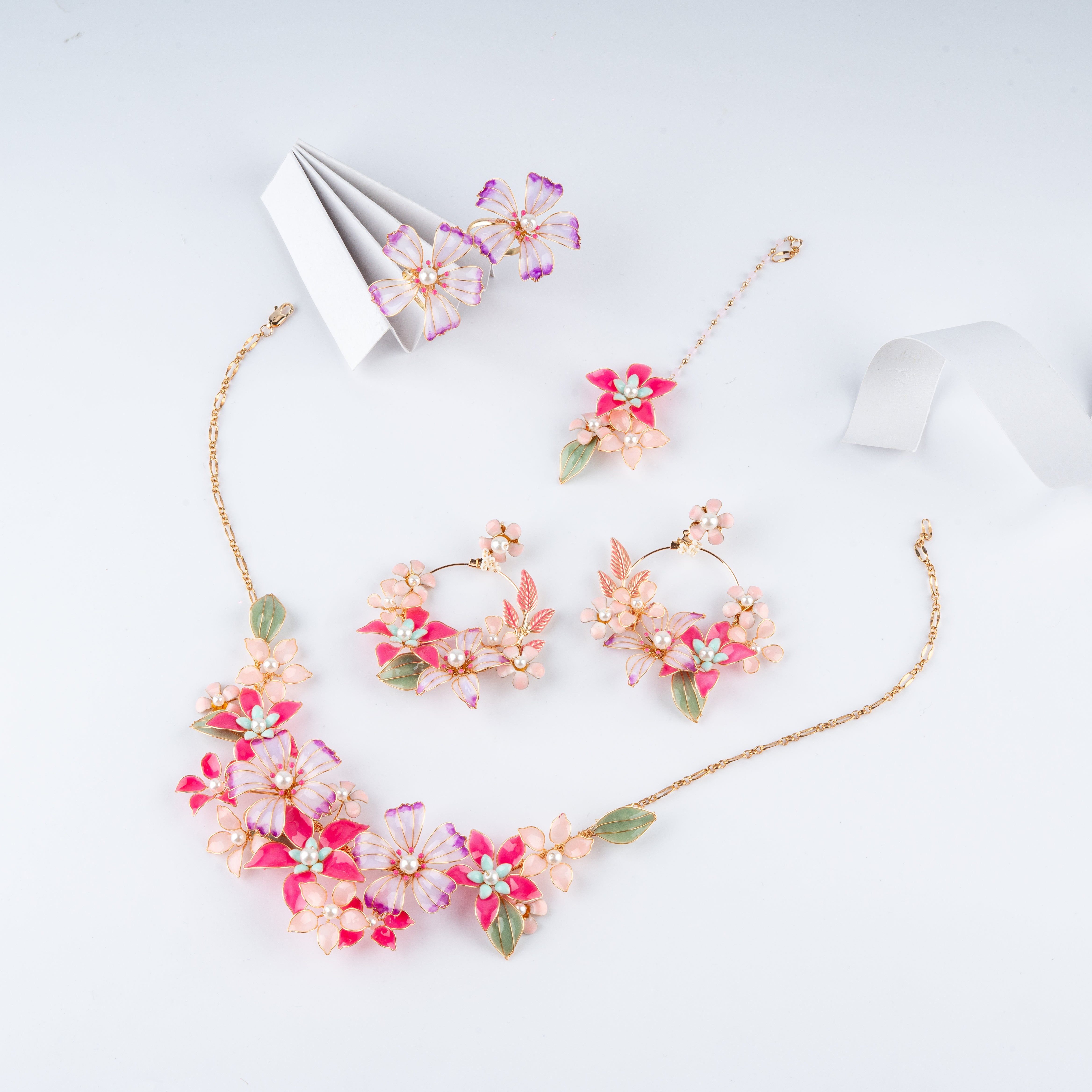 Pink and white floral resin jewelry set with necklace, hoop earrings, maang tikka, and rings from US Catalog.